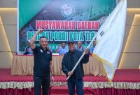Muhammad Sinen menyerahkan bendera pataka kepada Ketua PORDI Kota Ternate terpilih periode 2026–2030 Nasri Abubakar, Minggu (11/10/2026).