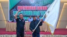 Muhammad Sinen menyerahkan bendera pataka kepada Ketua PORDI Kota Ternate terpilih periode 2026–2030 Nasri Abubakar, Minggu (11/10/2026).